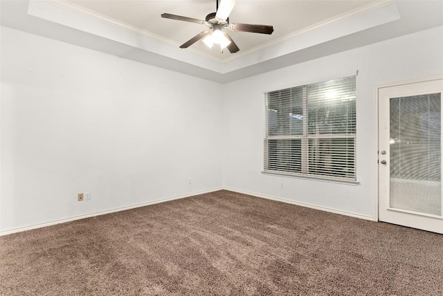 spare room with a tray ceiling, ceiling fan, crown molding, and carpet floors