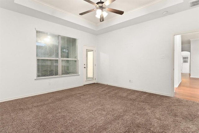 carpeted empty room featuring a tray ceiling, ceiling fan, and ornamental molding