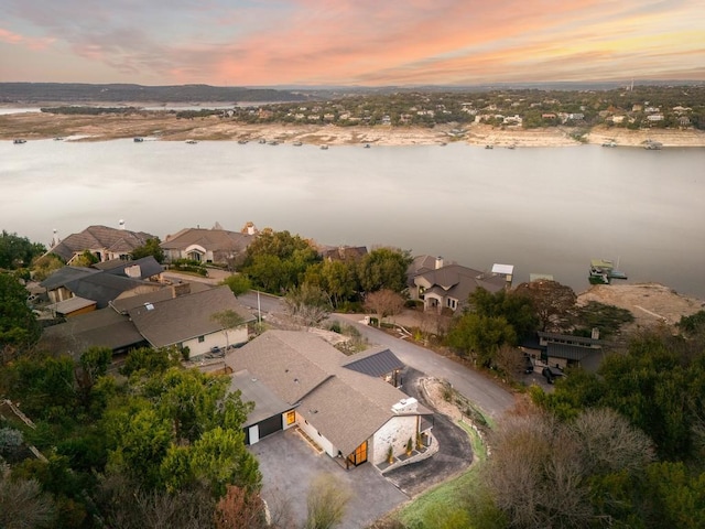 aerial view at dusk featuring a water view