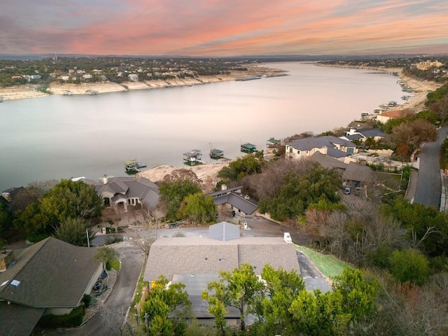 aerial view at dusk featuring a water view