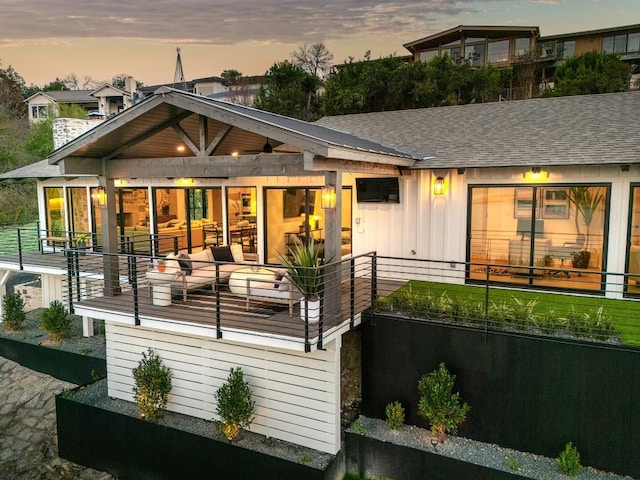 back house at dusk with a balcony