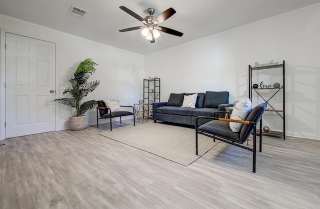 living room with ceiling fan and light hardwood / wood-style flooring