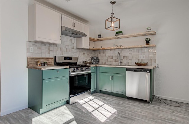 kitchen with white cabinets, stainless steel appliances, hanging light fixtures, and green cabinetry