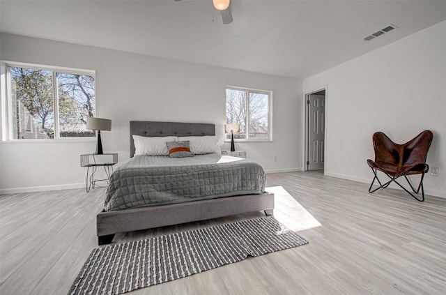 bedroom with ceiling fan, light wood-type flooring, and multiple windows