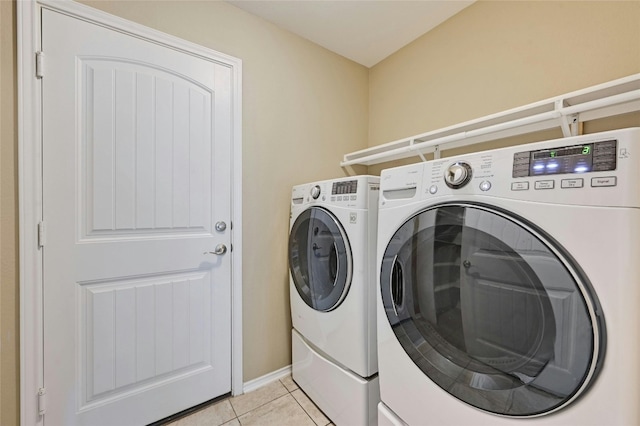 laundry room featuring light tile patterned floors and washer and dryer