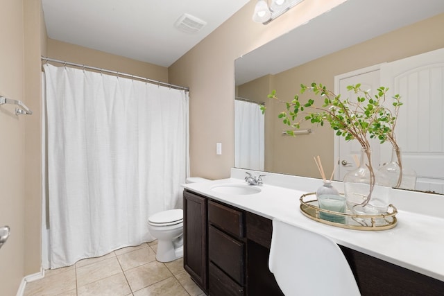 bathroom with toilet, vanity, and tile patterned floors