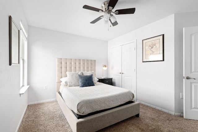 carpeted bedroom with ceiling fan and a closet