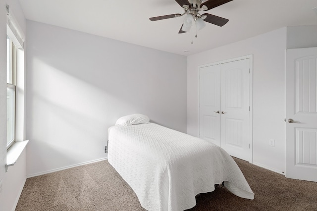 carpeted bedroom featuring multiple windows, ceiling fan, and a closet