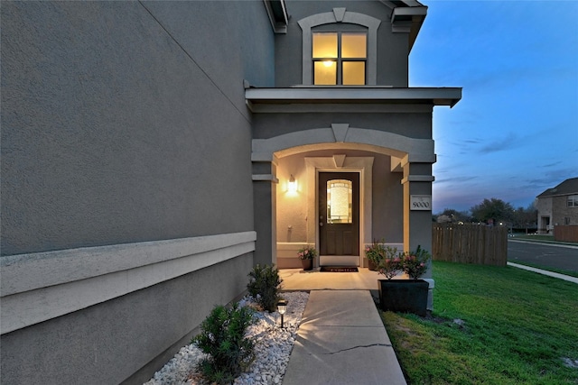 exterior entry at dusk with a lawn