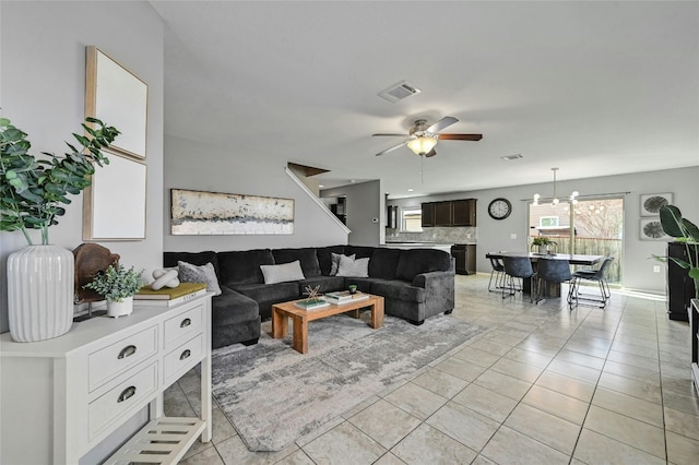 living room featuring light tile patterned floors and ceiling fan with notable chandelier