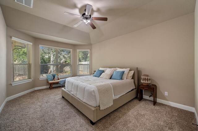 bedroom featuring carpet flooring, ceiling fan, a raised ceiling, and vaulted ceiling