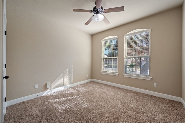 unfurnished room with ceiling fan and carpet