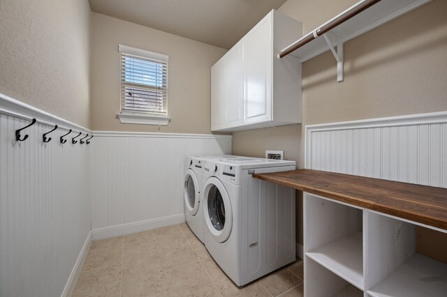 laundry room featuring washer and dryer, light tile patterned floors, and cabinets