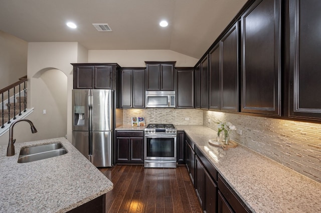 kitchen with decorative backsplash, light stone countertops, sink, and appliances with stainless steel finishes