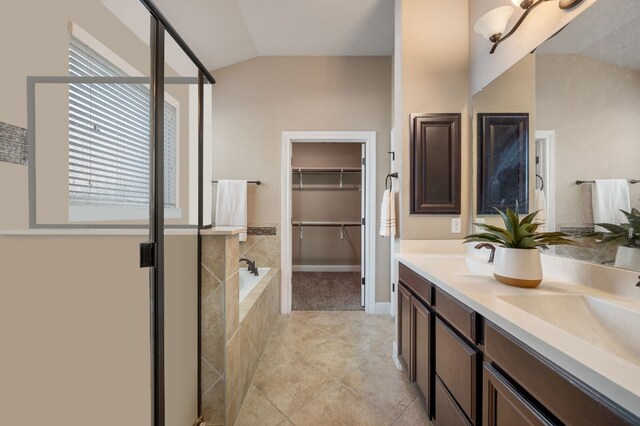 bathroom with vanity, independent shower and bath, and vaulted ceiling