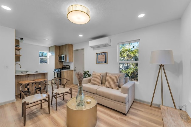living room with baseboards, light wood-style flooring, a wall mounted air conditioner, and a wealth of natural light
