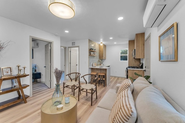 living room featuring light hardwood / wood-style floors and a wall mounted AC