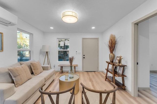 living room featuring light wood-type flooring and an AC wall unit