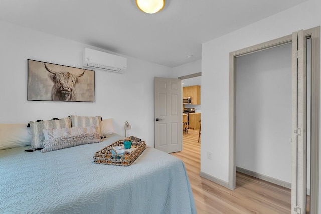 bedroom featuring an AC wall unit, light wood finished floors, and baseboards