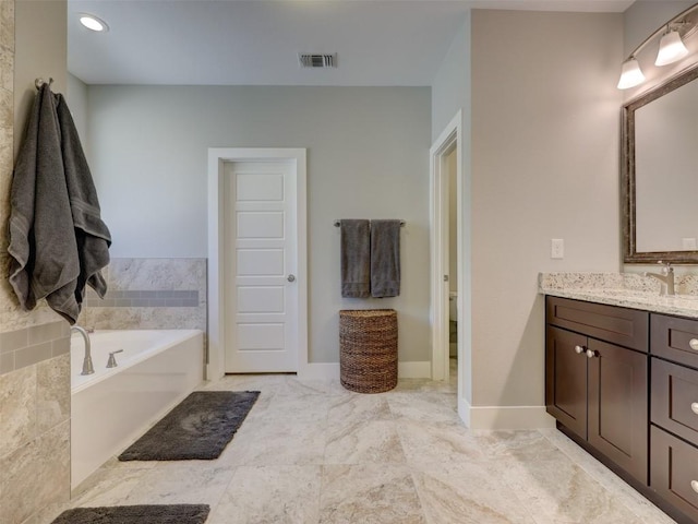 bathroom featuring a bath, vanity, and toilet