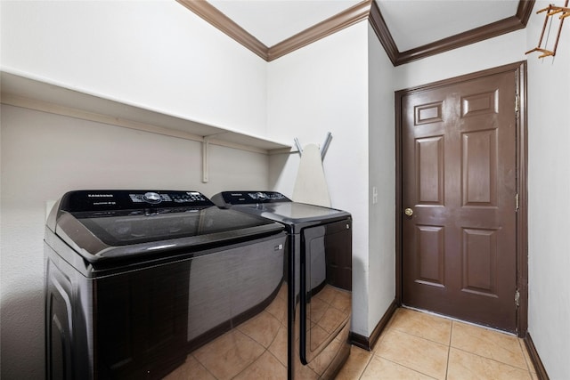 laundry room featuring light tile patterned floors, crown molding, and washing machine and clothes dryer