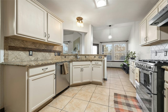 kitchen featuring kitchen peninsula, appliances with stainless steel finishes, vaulted ceiling, extractor fan, and hanging light fixtures