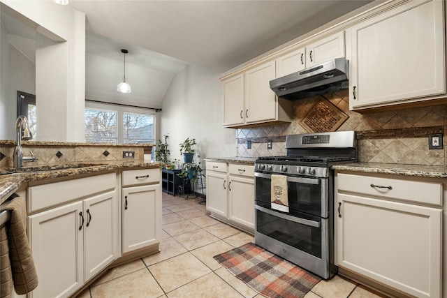 kitchen featuring pendant lighting, double oven range, sink, vaulted ceiling, and light stone counters