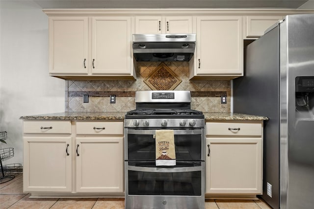 kitchen featuring light stone countertops, stainless steel appliances, extractor fan, cream cabinets, and light tile patterned floors