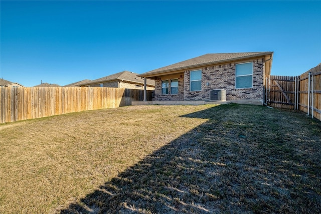 back of house with a lawn and central AC