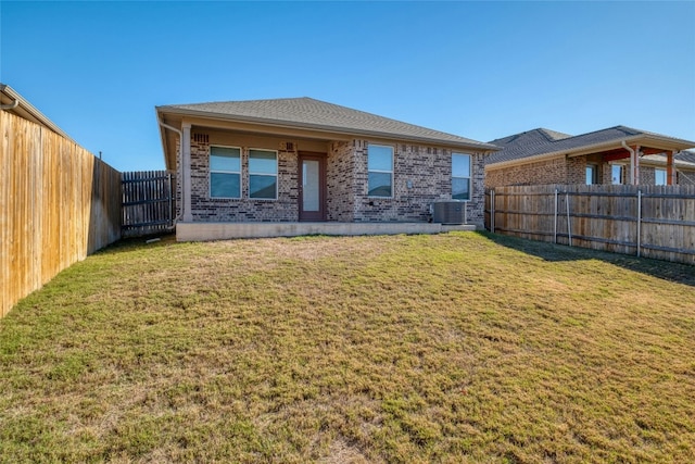 back of house featuring central AC unit and a lawn