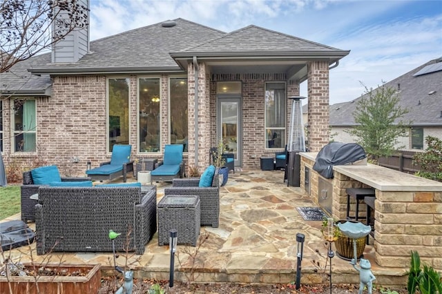 view of patio / terrace featuring a bar, area for grilling, outdoor lounge area, and exterior kitchen