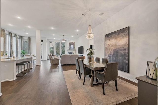 dining space featuring dark hardwood / wood-style flooring, sink, and ceiling fan