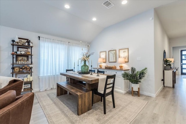 dining area with light hardwood / wood-style floors and vaulted ceiling