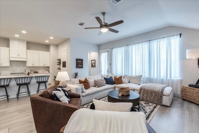 living room with ceiling fan, plenty of natural light, and light wood-type flooring