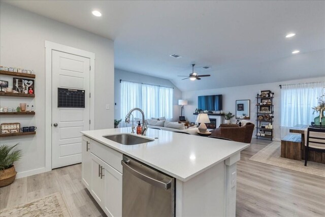 kitchen with dishwasher, sink, light hardwood / wood-style flooring, an island with sink, and white cabinetry