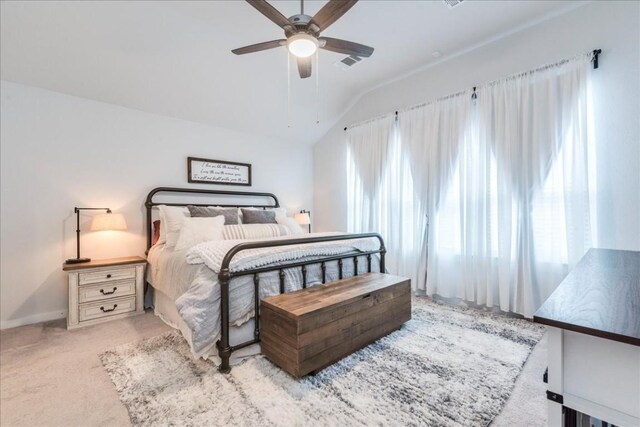 carpeted bedroom featuring ceiling fan, vaulted ceiling, and multiple windows