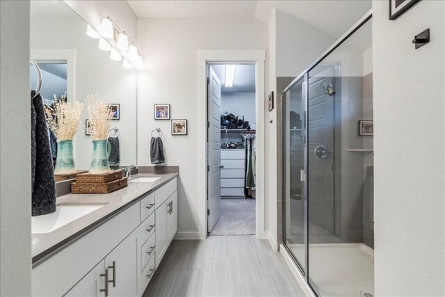 bathroom with a shower with door and vanity