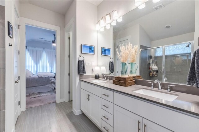 bathroom featuring ceiling fan, a shower with door, vanity, and lofted ceiling