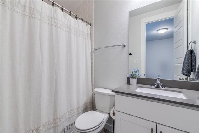 bathroom with vanity, a shower with shower curtain, and toilet