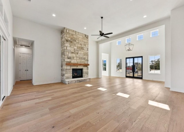 265 Gaucho Way, Dripping Springs, TX 78620 - unfurnished living room featuring a ceiling fan, a towering ceiling, light wood-style flooring, attic access, and recessed lighting