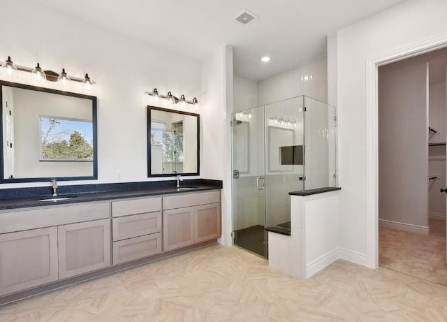 bathroom with vanity and a shower with door