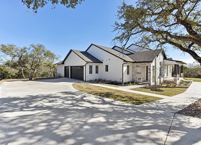 265 Gaucho Way, Dripping Springs, TX 78620 - view of property exterior with stone siding, an attached garage, driveway, and a shingled roof