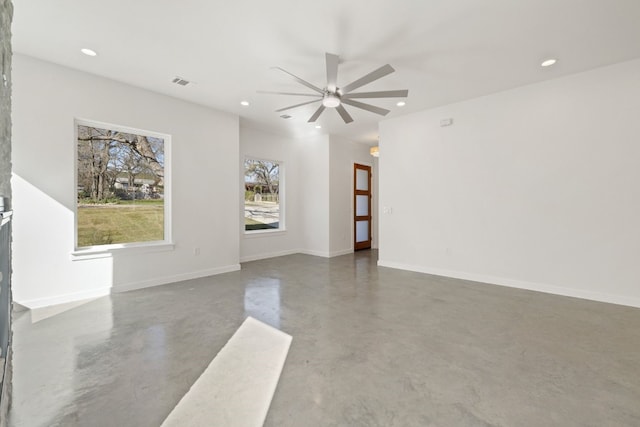 spare room featuring ceiling fan and concrete floors