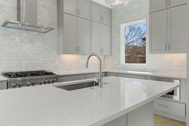 kitchen featuring tasteful backsplash, sink, and wall chimney range hood