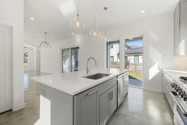 kitchen with stainless steel appliances, a healthy amount of sunlight, sink, gray cabinets, and an island with sink