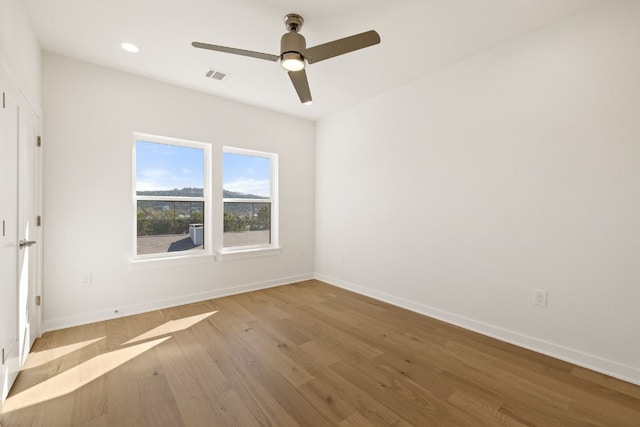 empty room with ceiling fan and light wood-type flooring