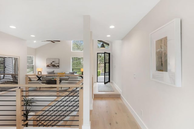 hallway featuring light hardwood / wood-style floors and lofted ceiling