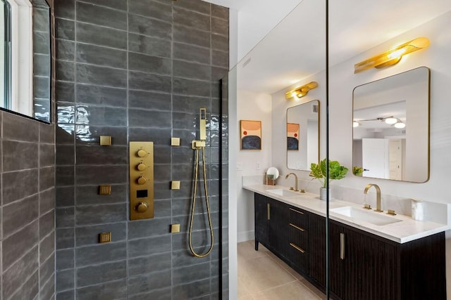 bathroom featuring a tile shower, vanity, and tile patterned floors