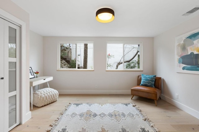 living area featuring light wood-type flooring and a wealth of natural light