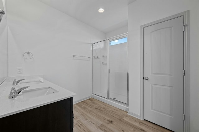 bathroom featuring vanity, wood-type flooring, and walk in shower